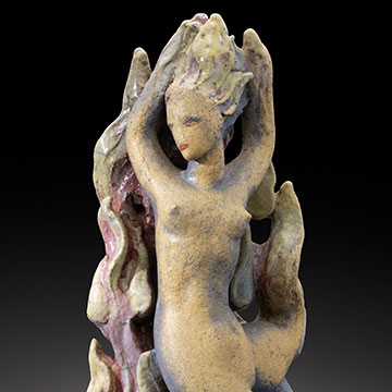 sculpture of a female figure with raised arms and hair standing on end in front of flames
